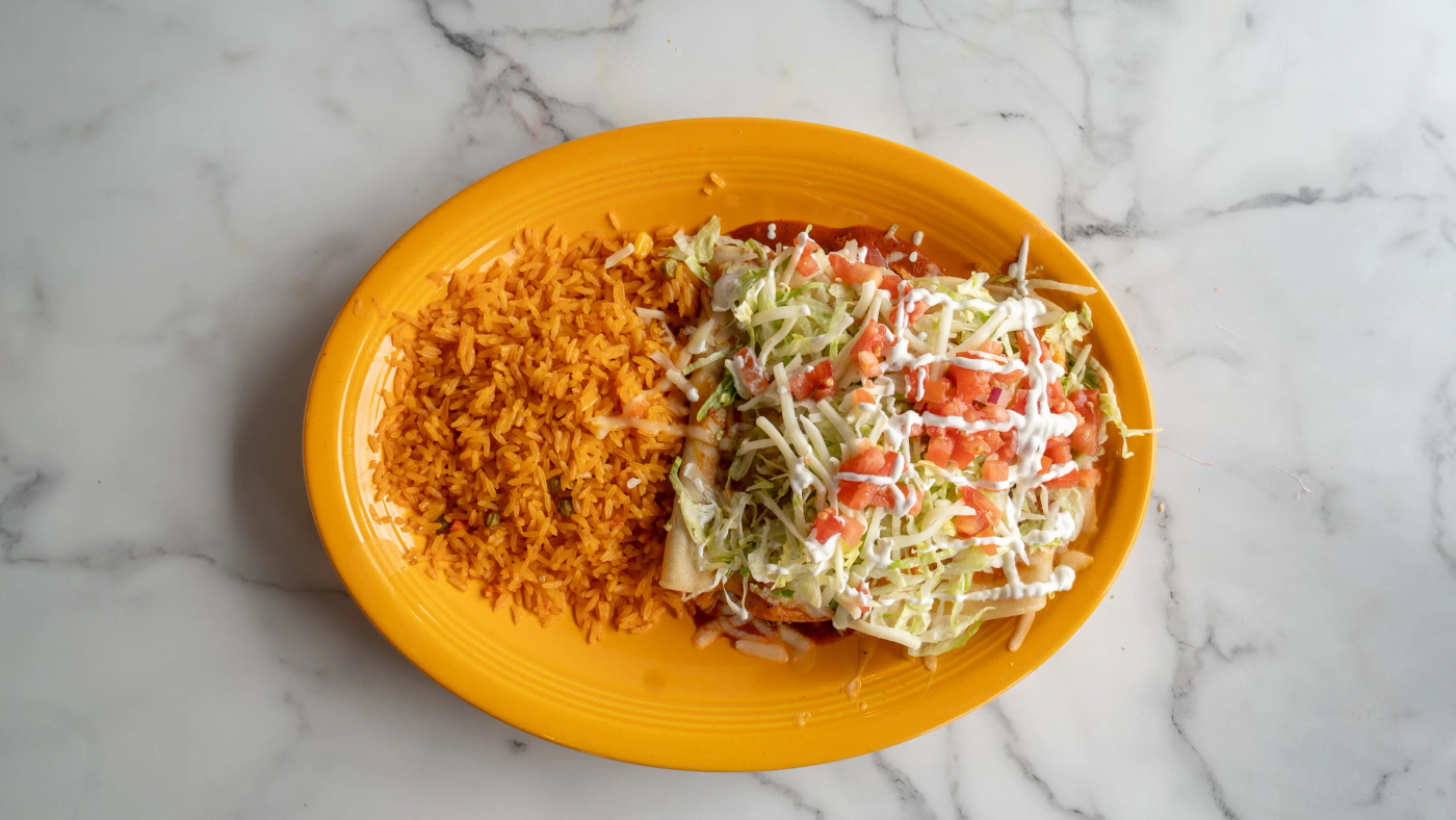 A supreme combination featuring one chicken enchilada, one cheese enchilada, one bean enchilada, and one beef enchilada, Topped with mild red or green sauce, cheese, lettuce, tomato, and sour cream. Served with a side of rice